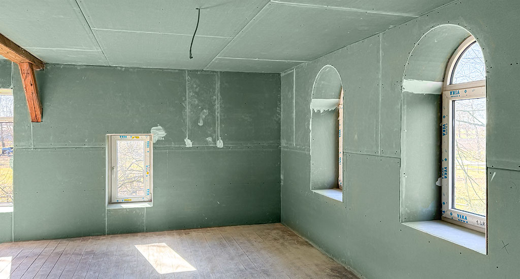 Altbau mit rohem Trockenbau mit rundfenstern im Vordergrund